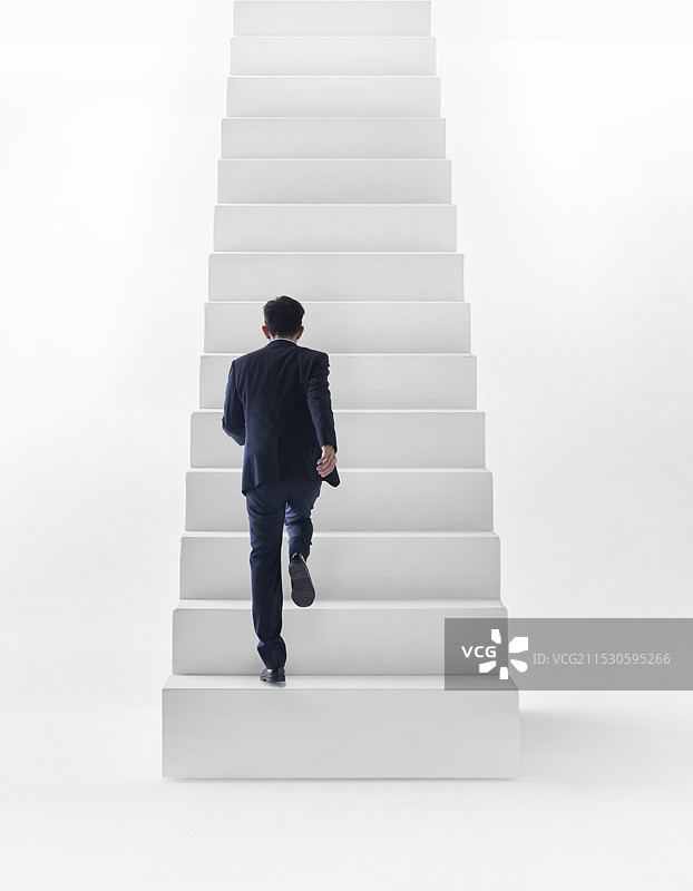 穿西装的男人在白色楼梯上奔跑图片素材