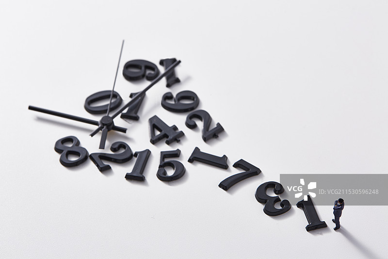 微型玩偶站在不连贯的数字和时钟指针前图片素材