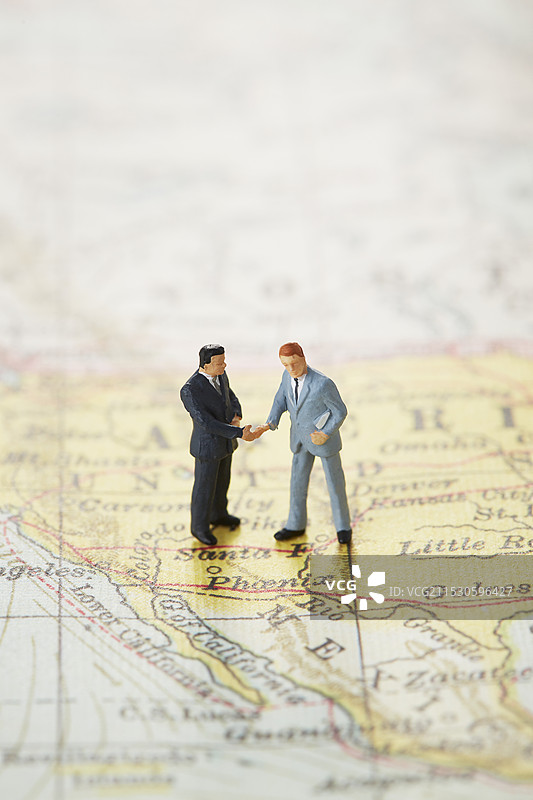 商人在世界地图上握手图片素材