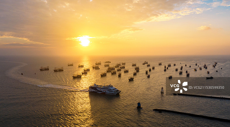 北海侨港迎着夕阳归港的船图片素材