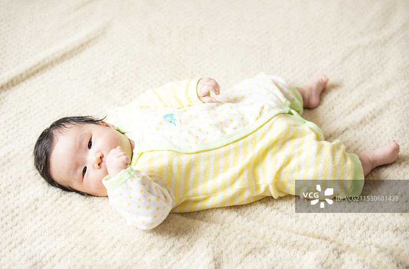 婴儿凝视着，同时吮吸手指图片素材