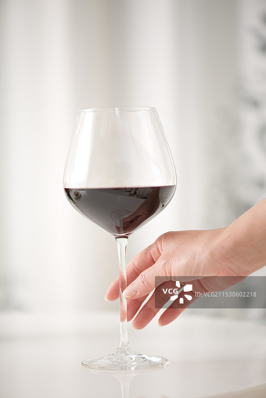 女人的手握着一杯红酒图片素材