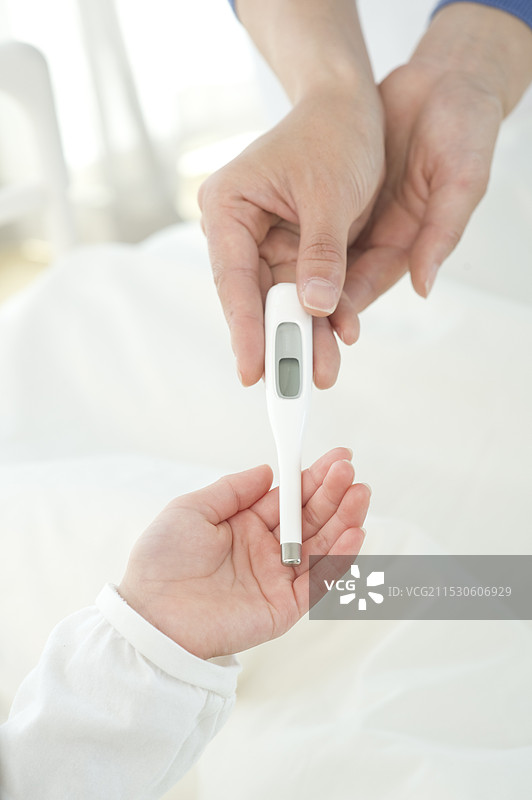 护士将温度计递给病床上的病人图片素材