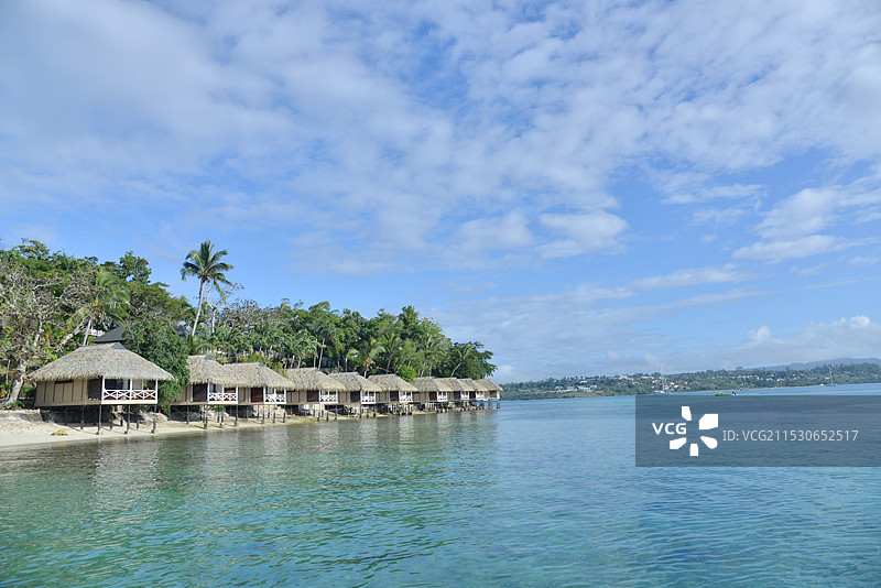 蓝天白云下建在海岛沙滩上的度假别墅酒店图片素材