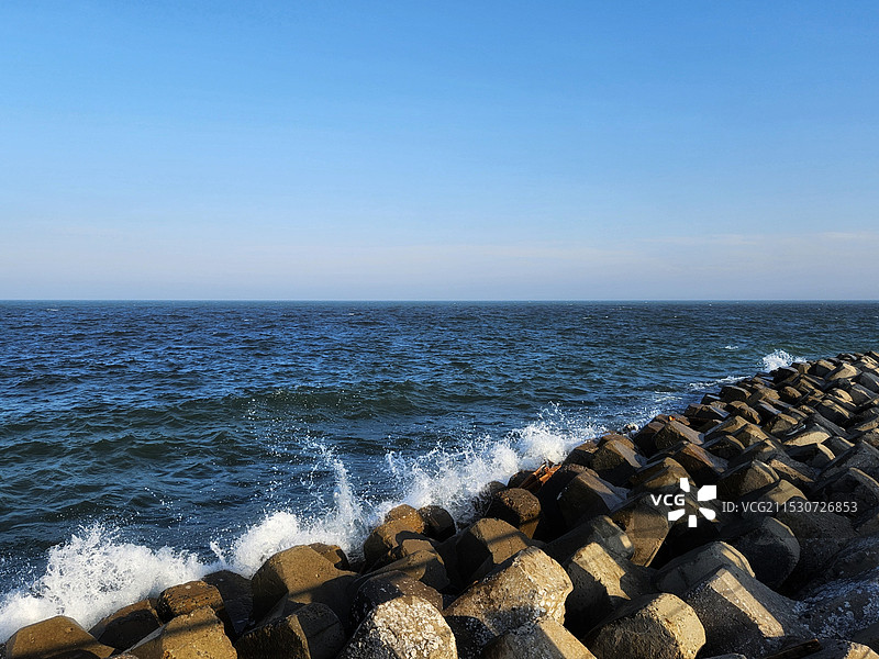 碧空映衬下的海滩岩石景观图片素材