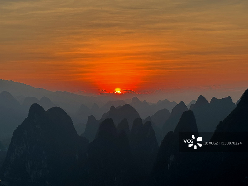 橘色天空衬托山峦的剪影景色图片素材