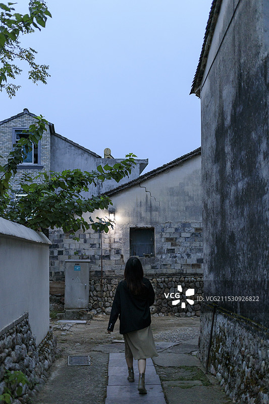 傍晚暮色下的前童古镇小巷街道，女子背影行走，宁波市宁海县图片素材