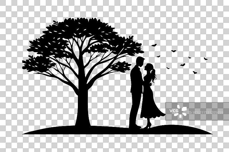 一对情侣在大树下相拥而立，创造出一种温馨的氛围图片素材