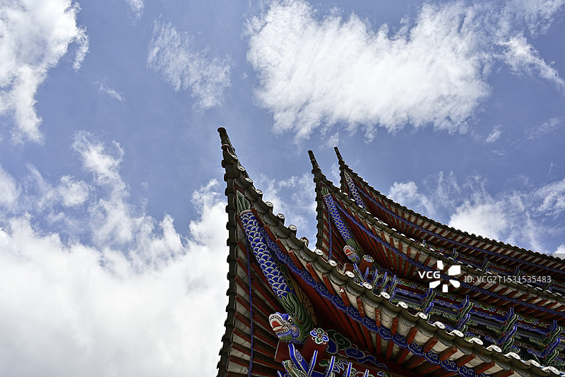 蓝天白云下的中式古建筑屋檐特写镜头（中国云南省大理古城“五华楼”挑檐部分局部侧面低视角特写）图片素材