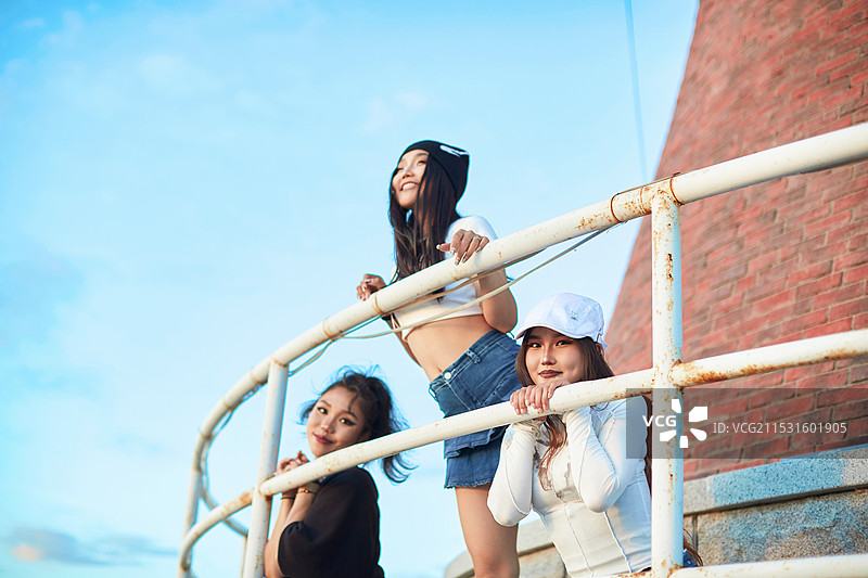 盛夏在草原湖边灯塔上拍照游玩的姑娘们图片素材