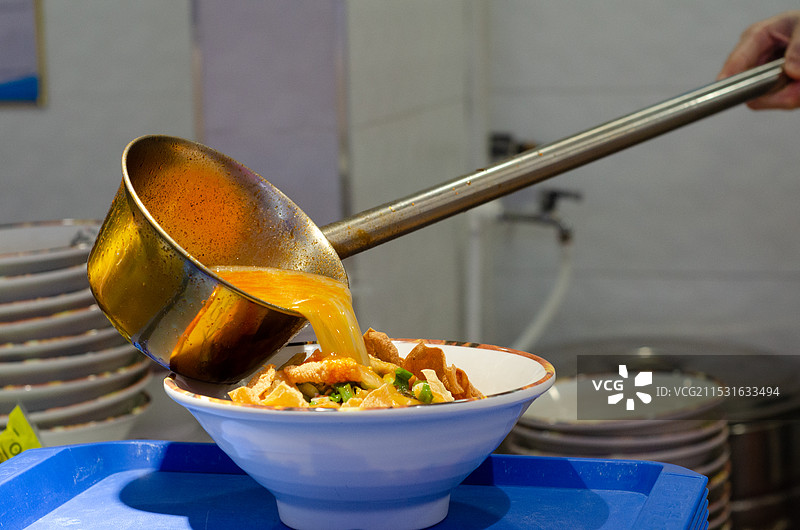 给碗中的螺蛳粉浇汤图片素材