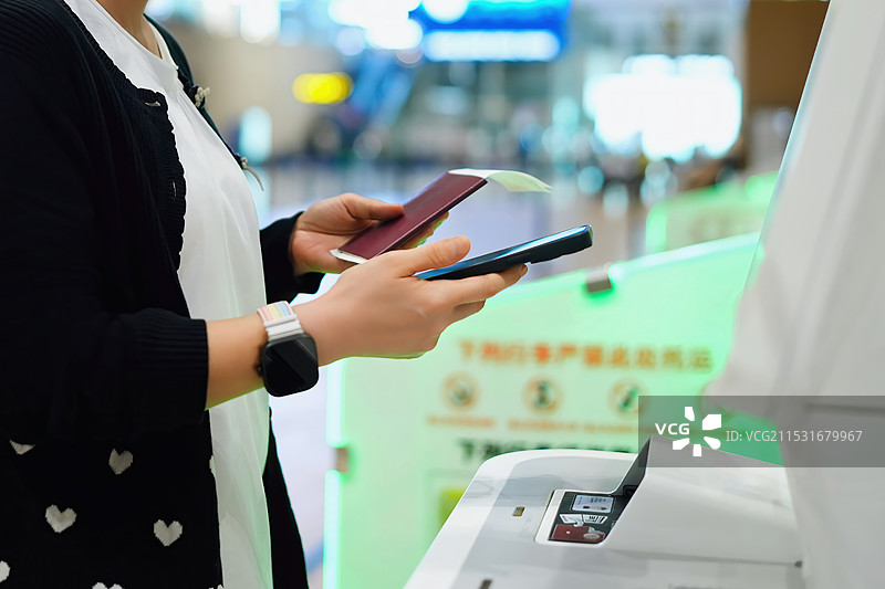在机场自助服务终端使用智能手机和护照办理高效旅客登机手续图片素材