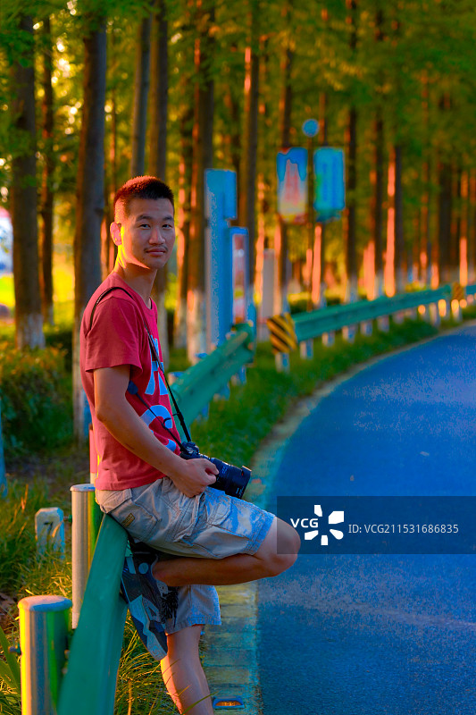 上海市横沙岛-夕阳下森林里的年轻人图片素材