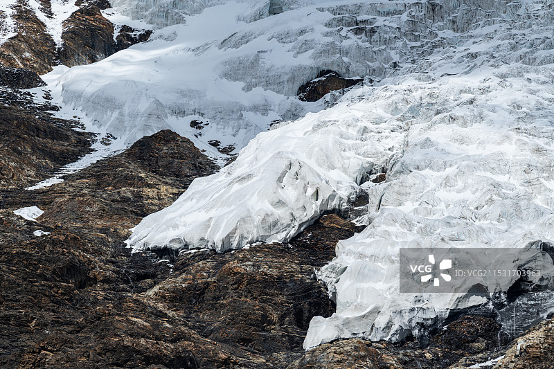西藏日喀则江孜县拉轨岗日山脉卡若拉冰川特写，洁白的冰舌覆盖在崎岖的山体岩石上图片素材