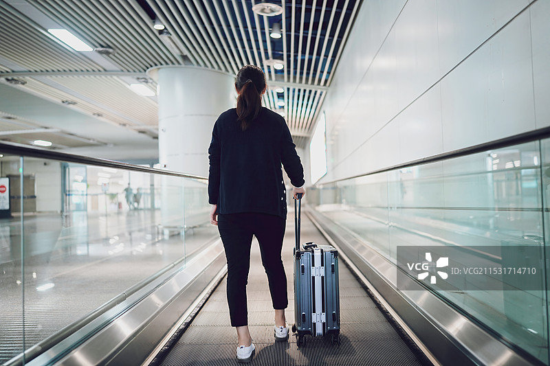 一个带着行李箱在机场独自旅行的人图片素材
