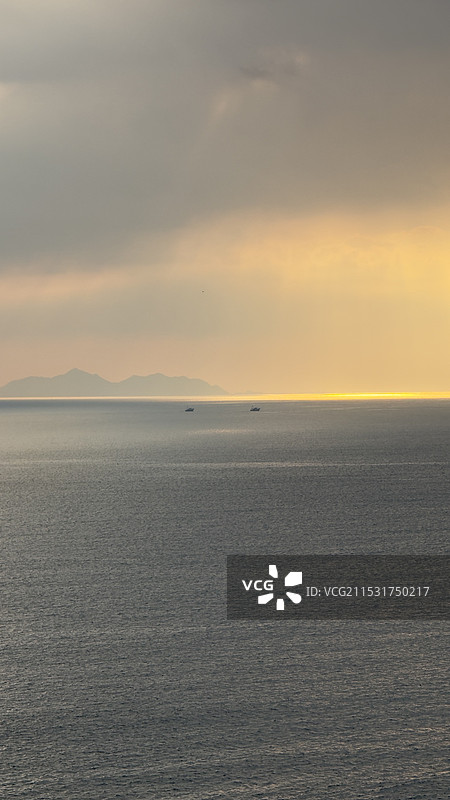 海面夕阳丁达尔效应与渔船图片素材
