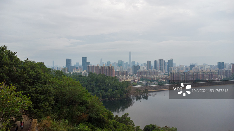 深圳：梅林水库和远处的平安金融中心等城市天际线图片素材