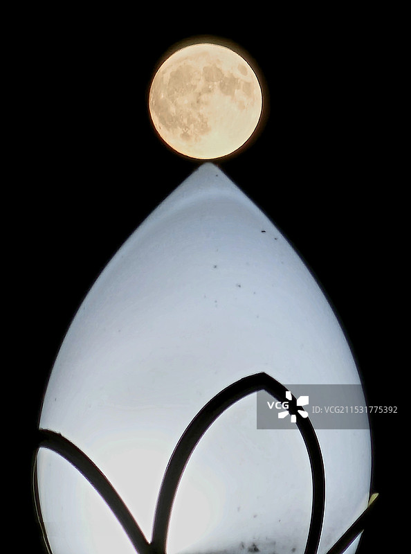 灯月交辉：十五的夜晚，皓月如镜，月亮如同一盏银色的灯笼，路灯洁白如玉，它们照亮了整个黑暗的天空。图片素材