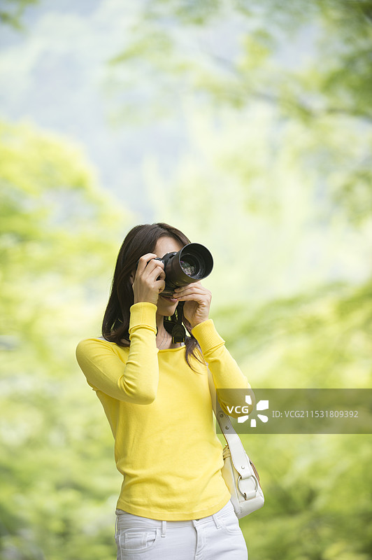 女性用单反相机拍照图片素材