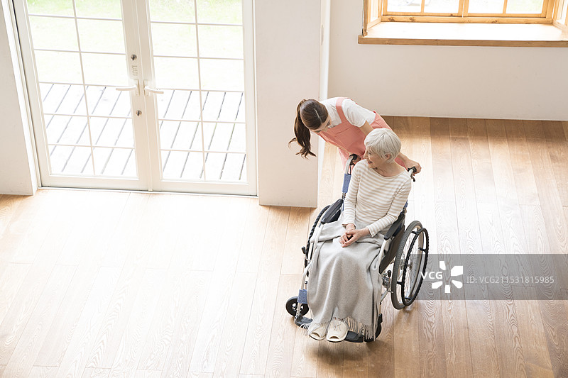 坐在轮椅上的老年女性与护理人员图片素材