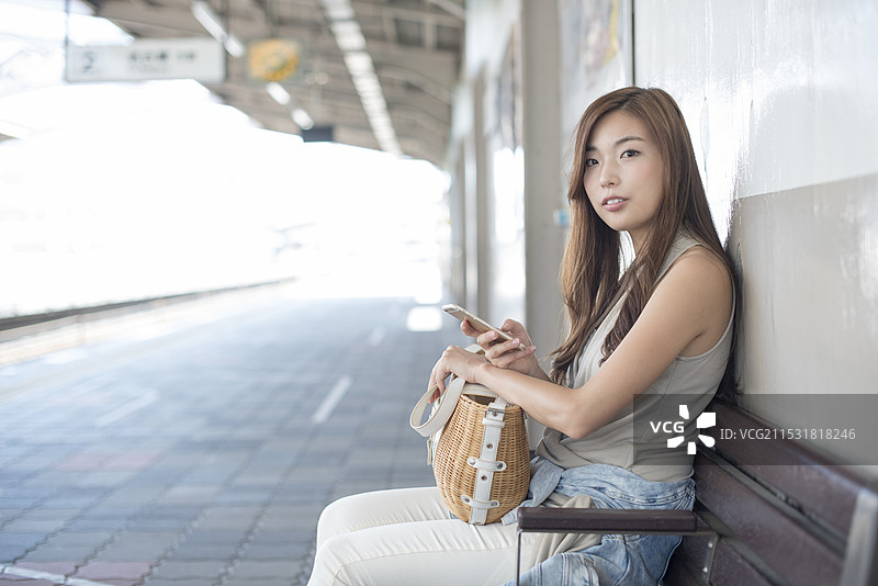 女人在车站长椅上等火车图片素材