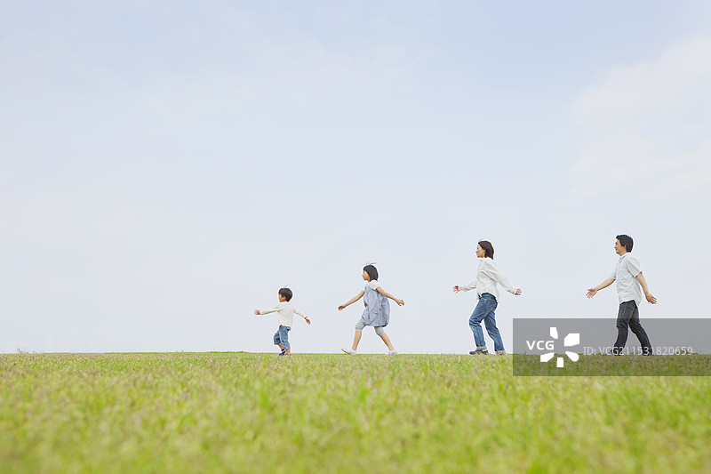 四口之家在草地上散步图片素材