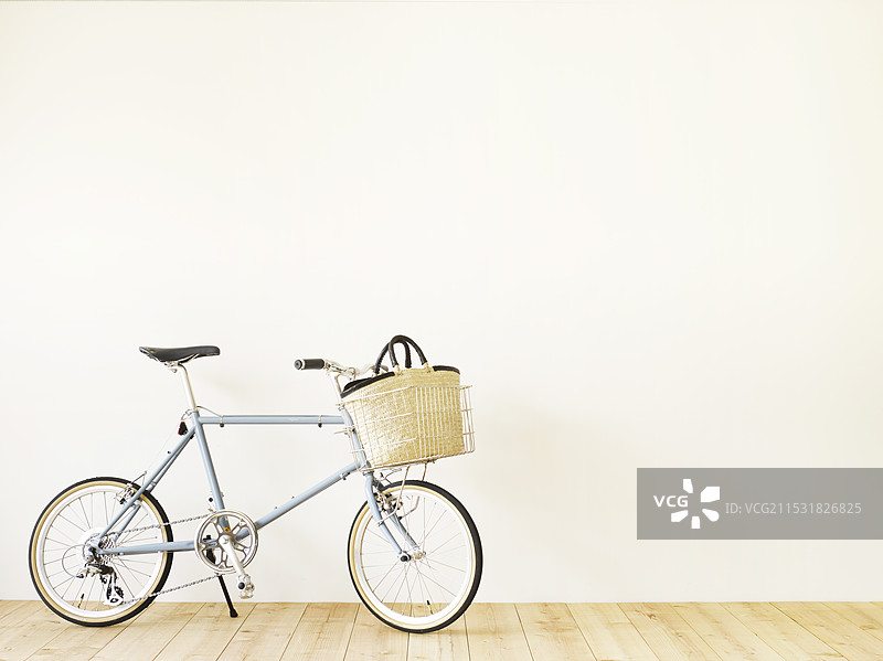 自行车、篮子包、木地板和白色墙壁图片素材
