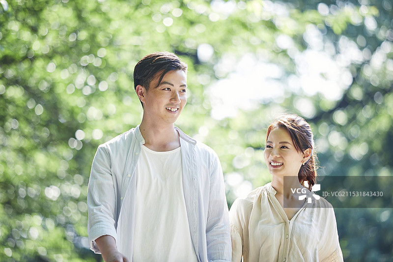 年轻男女在绿色环境中散步图片素材