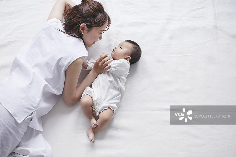 母亲和婴儿躺在白色背景上图片素材