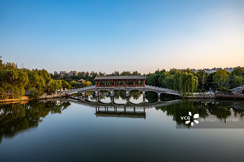 初秋黄昏晚霞中的山东德州董子园景区亭台楼榭桥建筑倒影景观图片素材