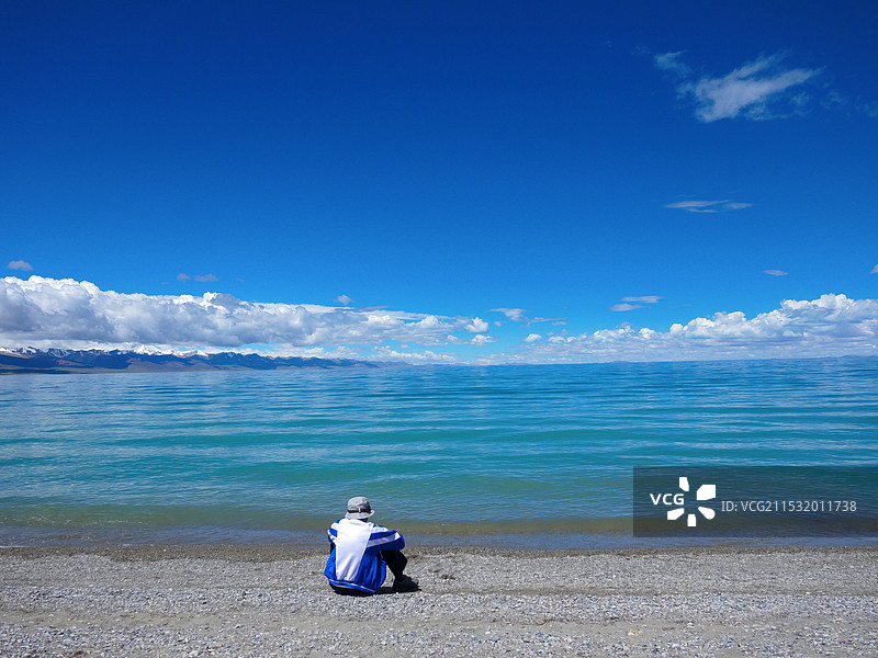 纳木错清澈湖面和游客背影图片素材