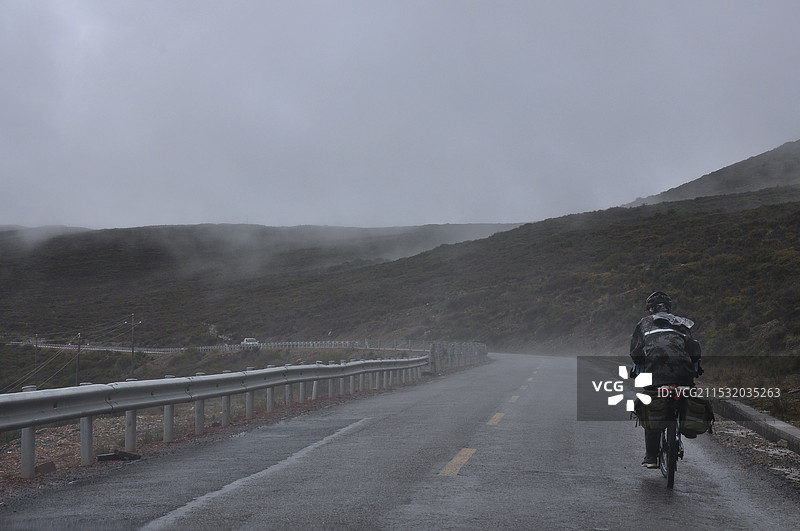 大雾天气下背着天空走在路上的人的后视图图片素材