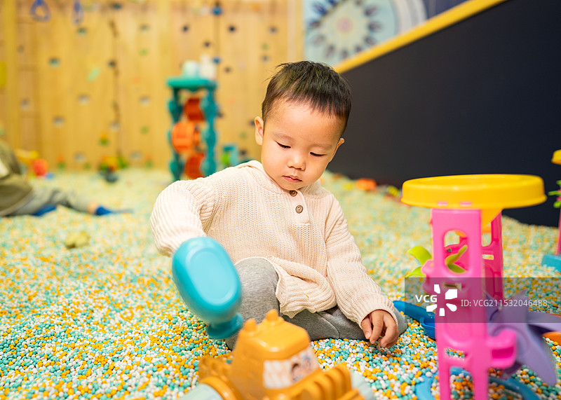 在室内儿童乐园玩耍的2岁小男孩图片素材