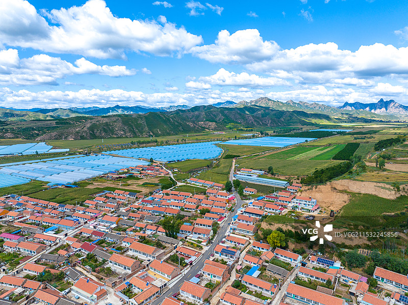 航拍北京延庆大山脚下的乡村和蓝色成片的农业蔬菜大棚图片素材