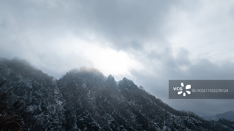 寒冷冬天山顶阳光透过云层图片素材
