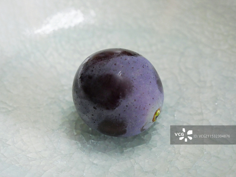 陶瓷盘中的一颗紫葡萄图片素材