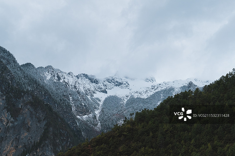 云南迪庆香格里拉巴拉格宗大峡谷白雪皑皑的群山映衬着多云的天空图片素材