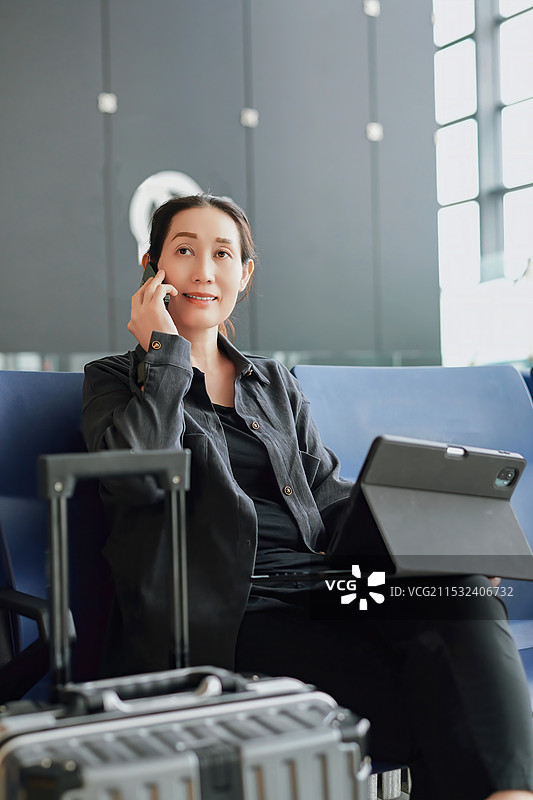 时尚的女商人带着行李旅行时从事工作图片素材