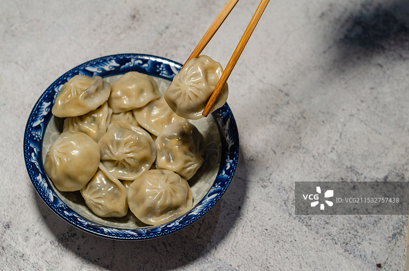 筷子夹起碗里的包子图片素材