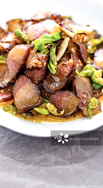桌上盘子里青椒炒腊肉美食食物的特写镜头图片素材
