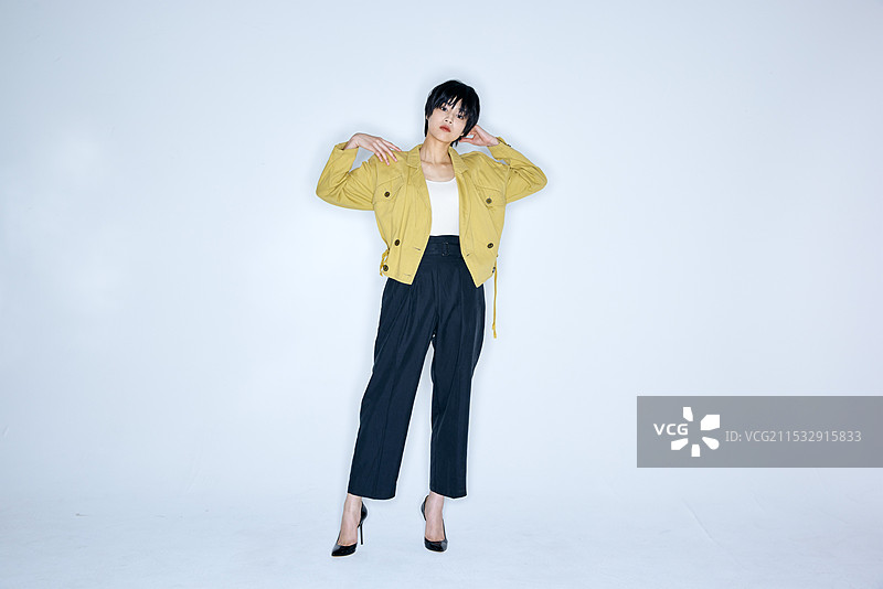 穿着黄色夹克和黑色裤子的日本女性图片素材