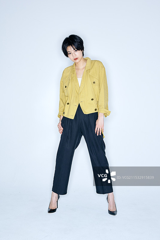 穿着黄色夹克和黑色裤子的日本女性图片素材