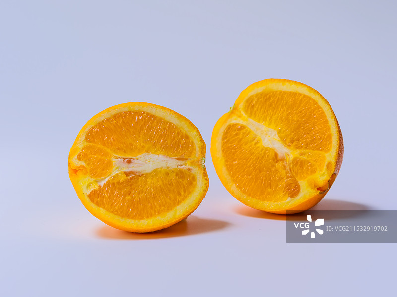 切半的橙子与白色留白背景的特写镜头图片素材