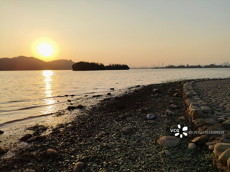 武汉东湖 落雁岛景区 卵石滩 日落夕阳 太阳照耀着鹅卵石沙滩图片素材