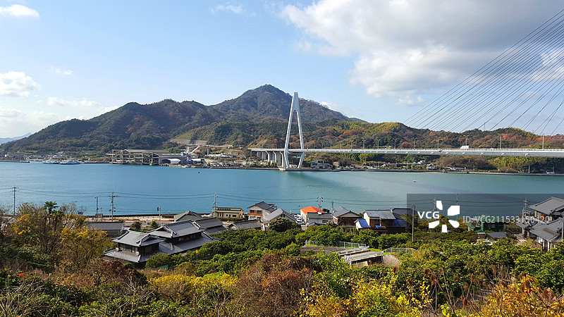 日本广岛县尾道市，岛波海道因岛段，濑户内海海岛上的农家和生口桥图片素材