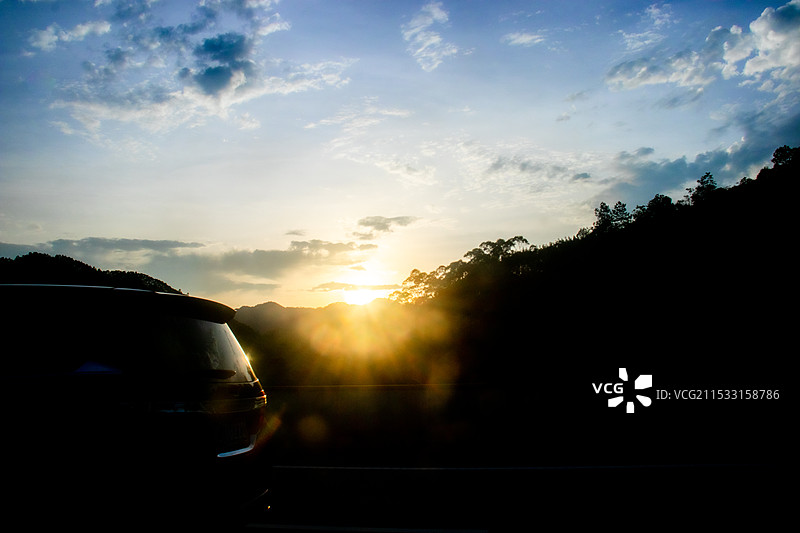 高速公路上车辆行驶在日出日落全景天空下旅途中在路上奔向未来光明商务插图图片素材