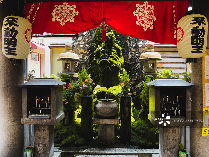 日本大阪法善寺被青苔覆盖的不动明王雕像图片素材