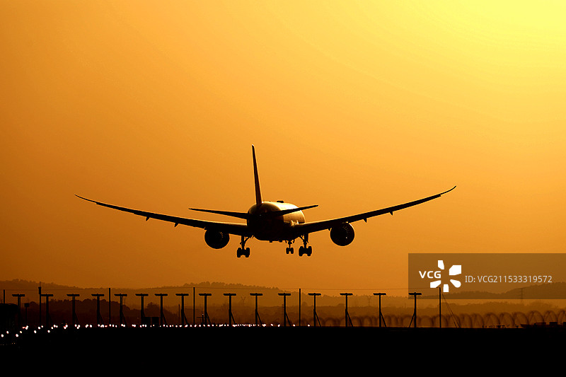 黄昏时分降落的民航飞机图片素材