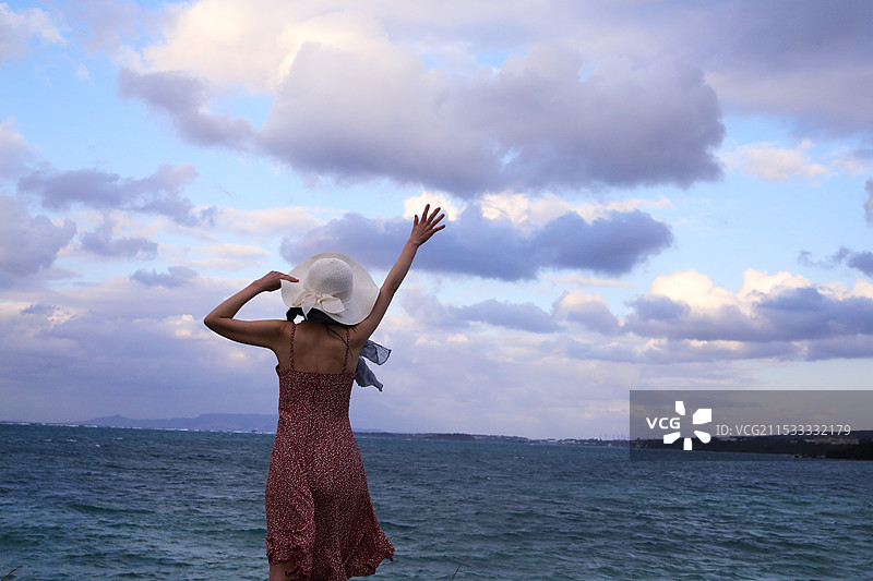 女人在冲绳享受天空和海洋的美景图片素材