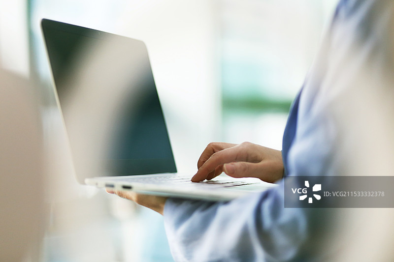 女性在操作笔记本电脑图片素材